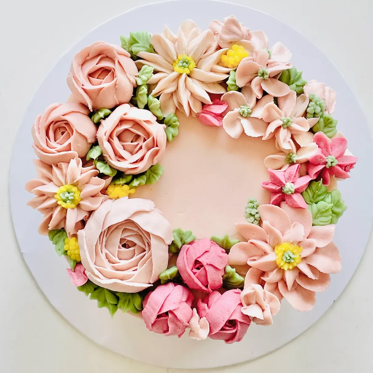A buttercream bloom wreath cake in blush tones
