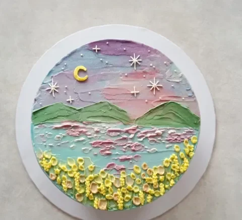 A dreamy mountainscape cake, hand-painted